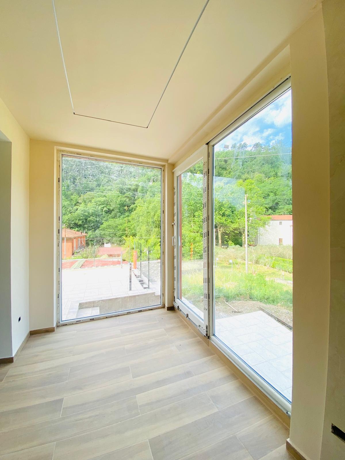 Una parete di vetro sul verde – Nuova costruzione con giardino privato